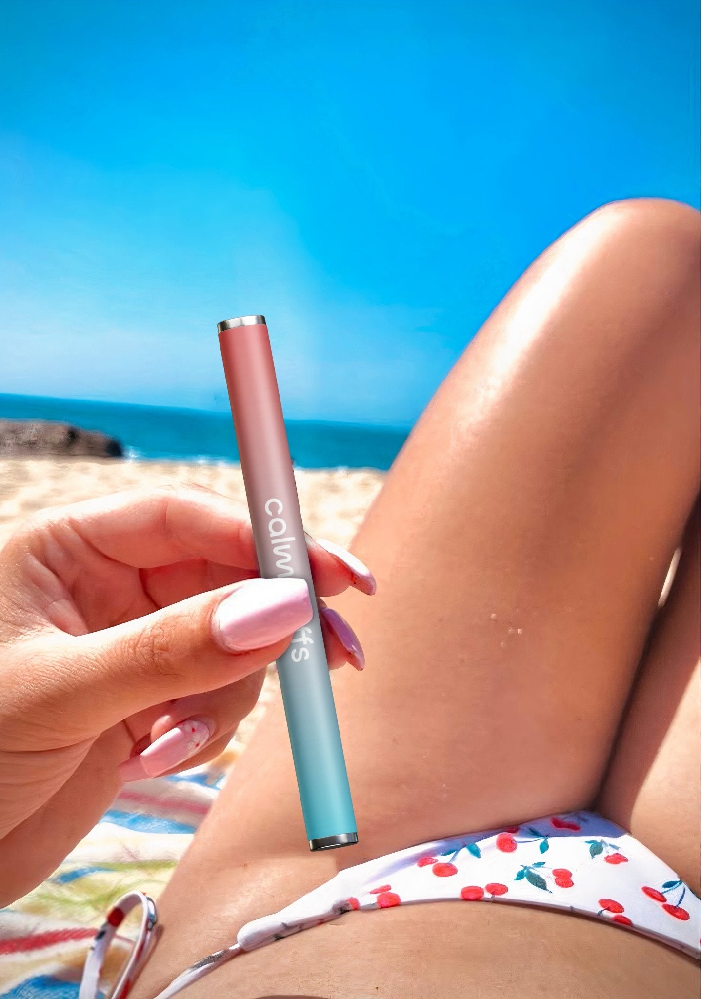 Calm Puffs Watermelon Vitamin C stick held at the beach on a bright summer day.