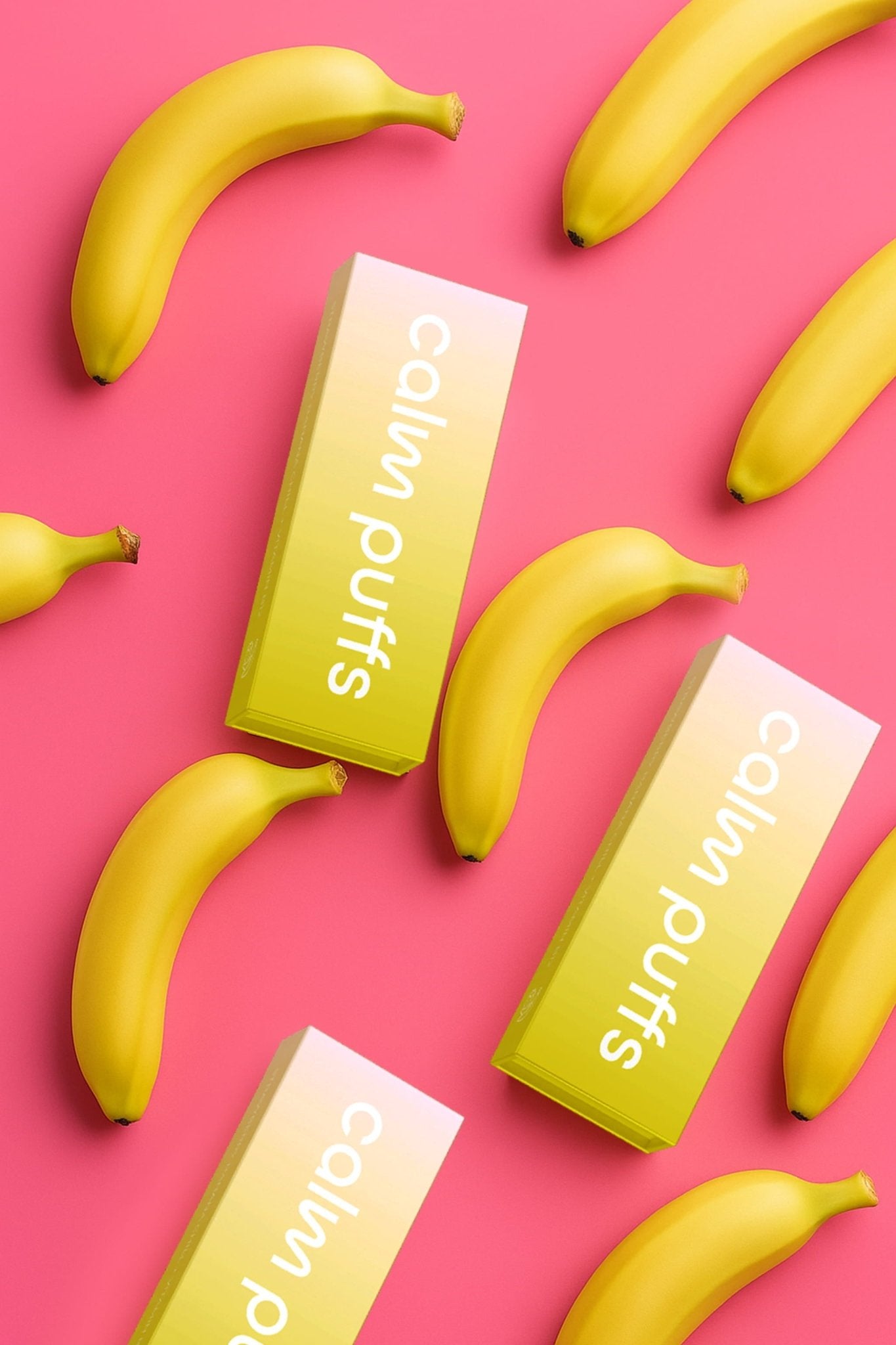 Calm Puffs Strawberry Banana Chill Vitamin B12 diffusers displayed with fresh bananas on a bright pink background